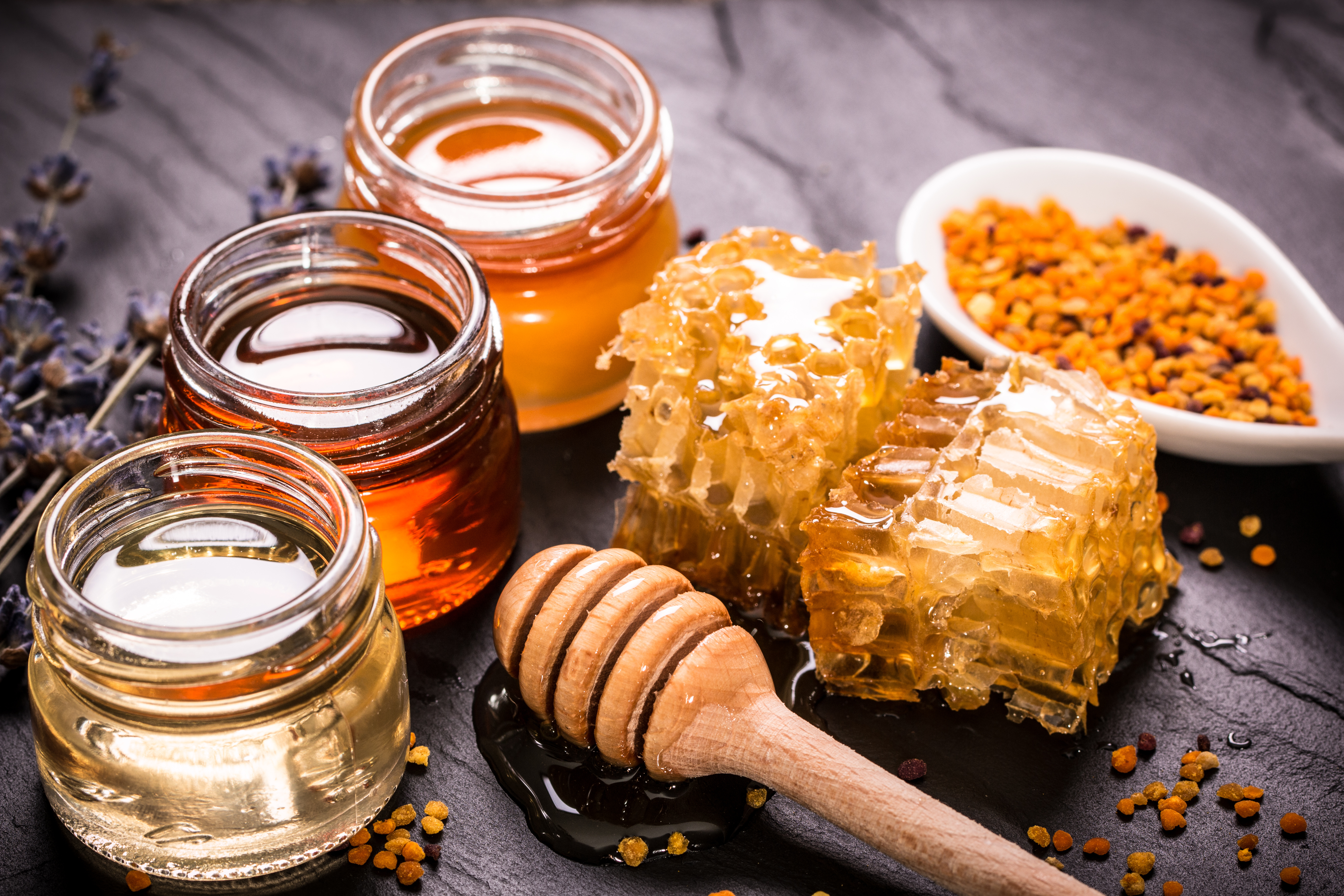 Honey In Jar With Honey Dipper On Black Stone