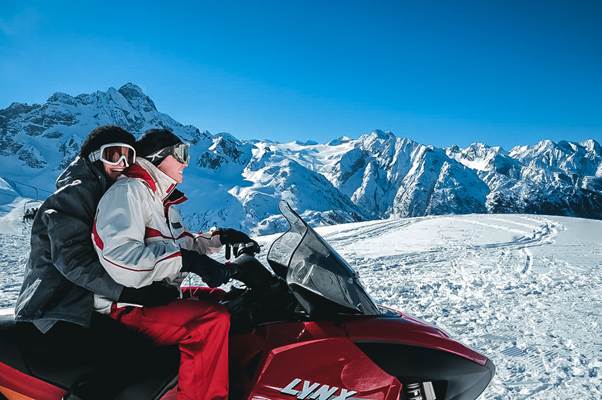 Due escursionisti impegnati in un escursione con la motoslitta in Lombardia e Passo del Tonale Due escursionisti impegnati in un escursione con la motoslitta in Lombardia e Passo del Tonale